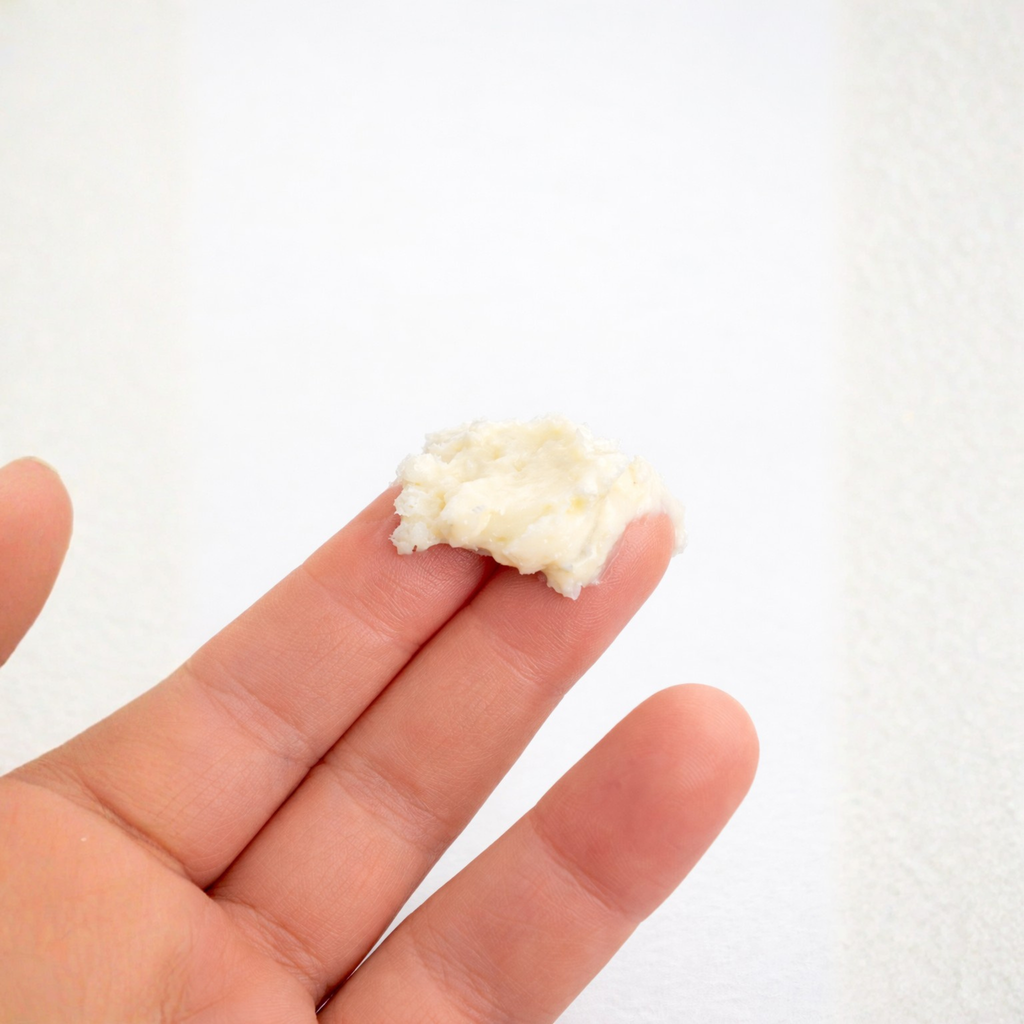 Hand holding a small amount of white rice on a plain background